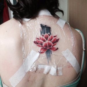 foto de una espalda con un tatuaje recién hecho con un plástico film encima