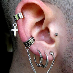 oreja masculina con muchos piercings